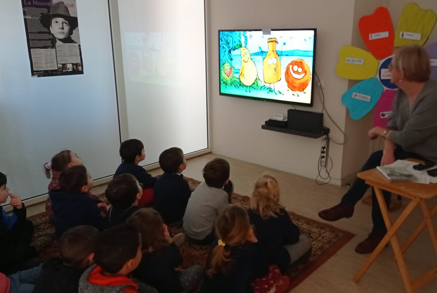 Animatrice avec un groupe d'enfants devant l'écran