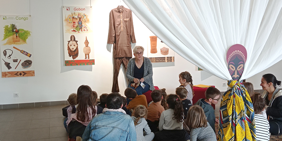 Les enfants et une bibliothécaire dans une salle d'exposition.